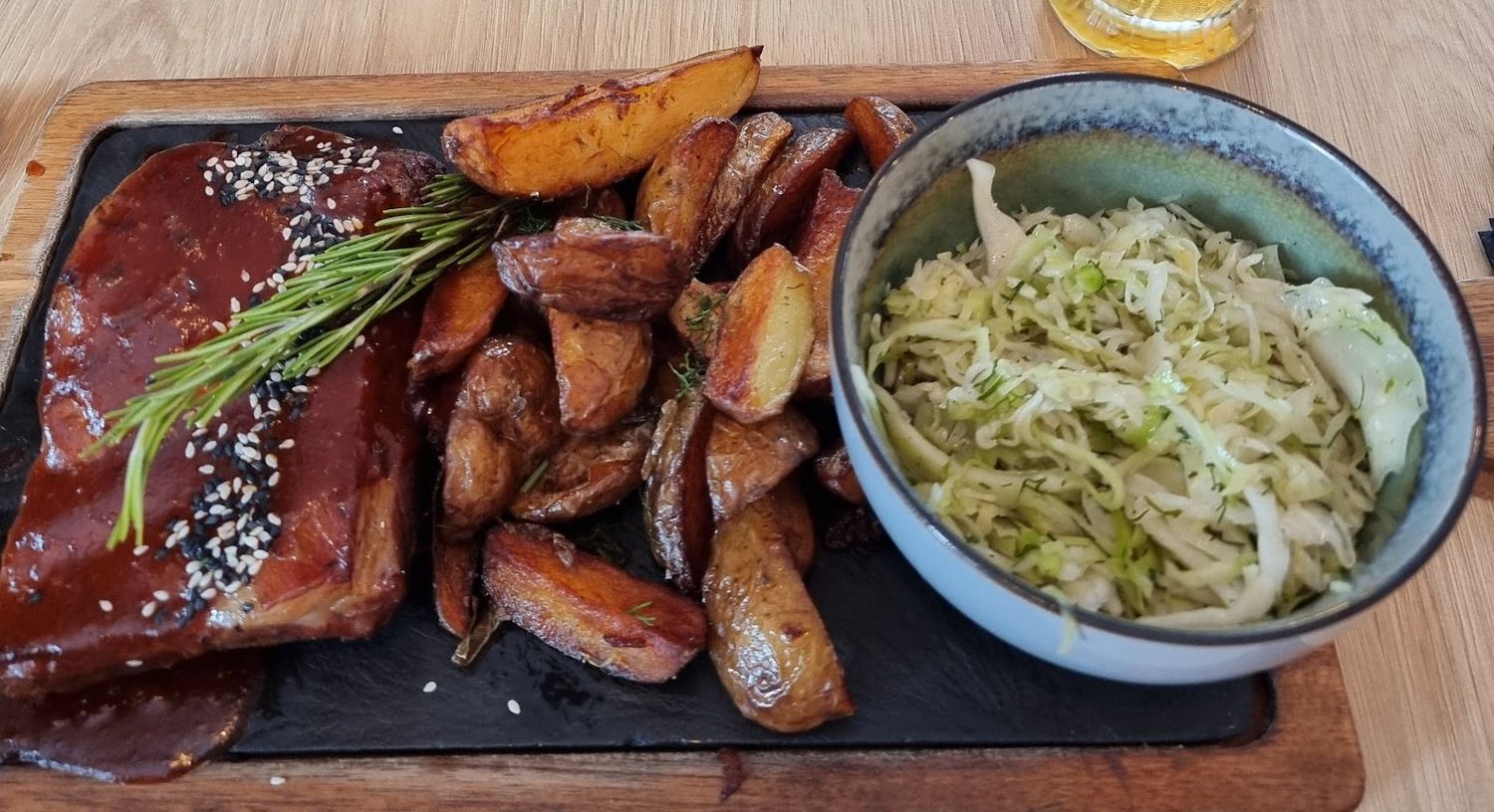 Żeberka BBQ z pieczonymi ziemniakami i surówką na kamiennym talerzu